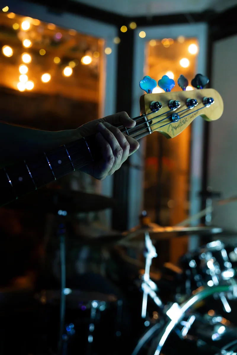 Close-up of a bass guitar with softly lit stage equipment