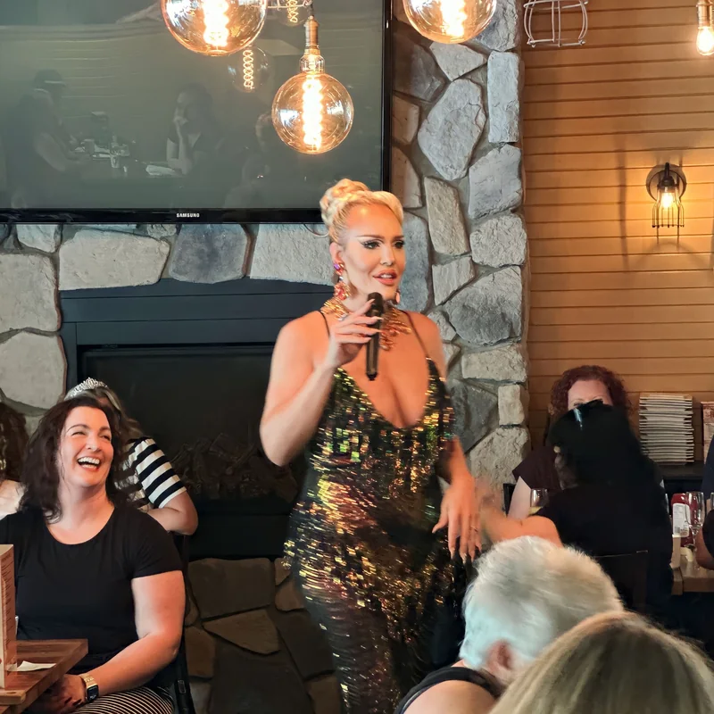 Kenadie St. James with a microphone, making guests laugh during brunch