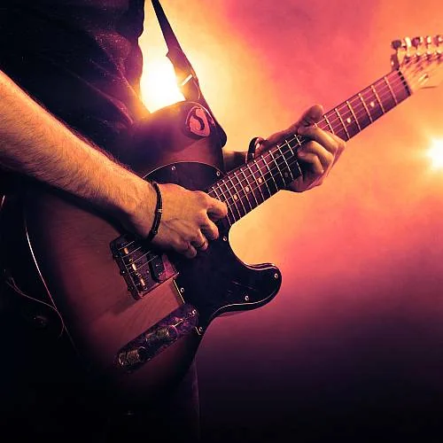 Close-up of an electric guitarist under stage lights
