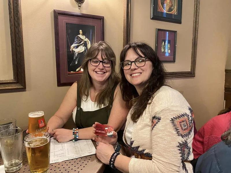 Friends playing trivia with answer sheets at their table