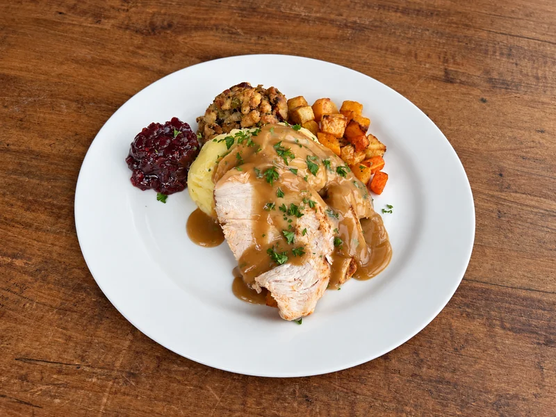 B Social turkey dinner with gravy, stuffing, potatoes, root vegetables and cranberry sauce